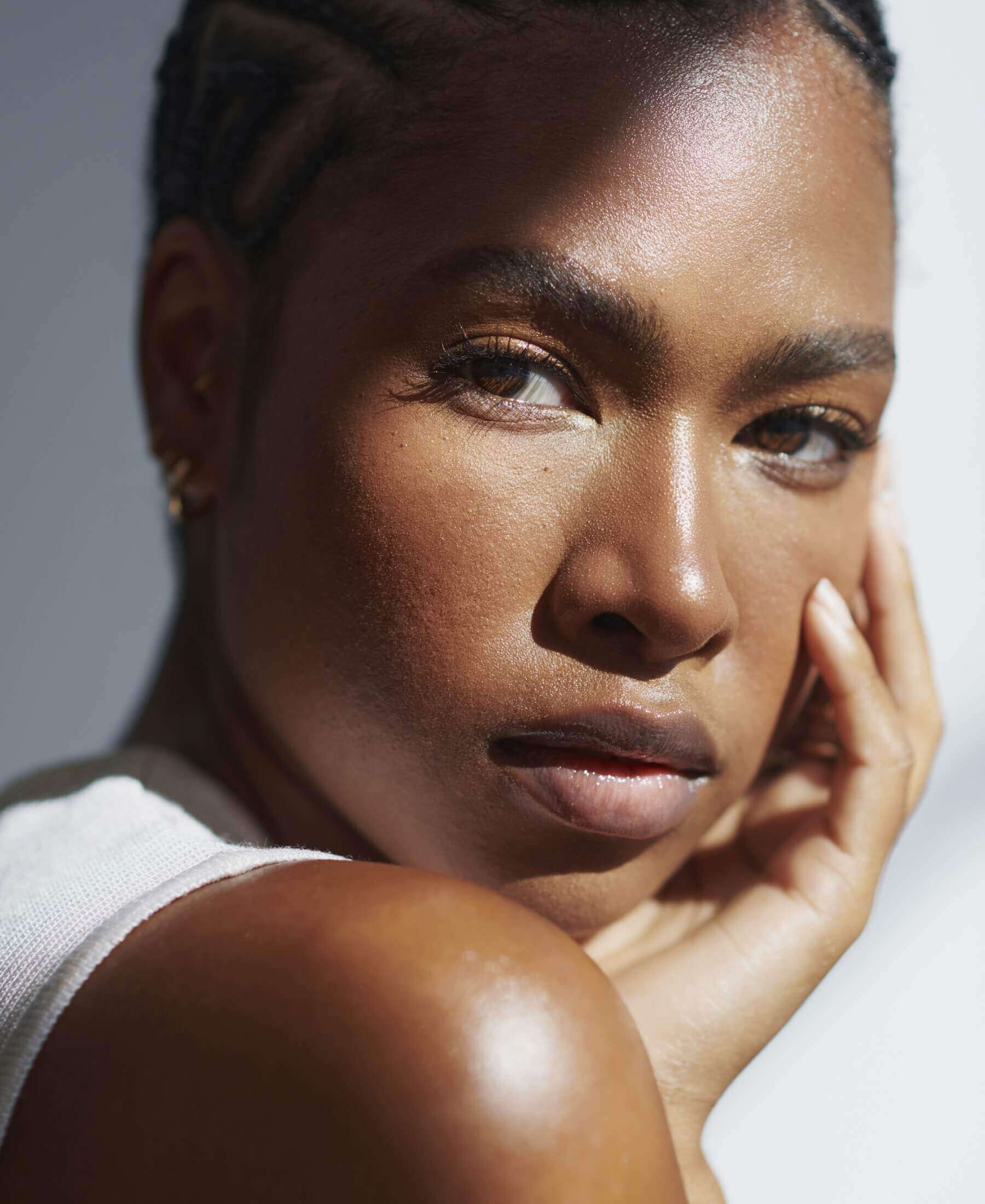a close up shot of a black woman with her hand against her face