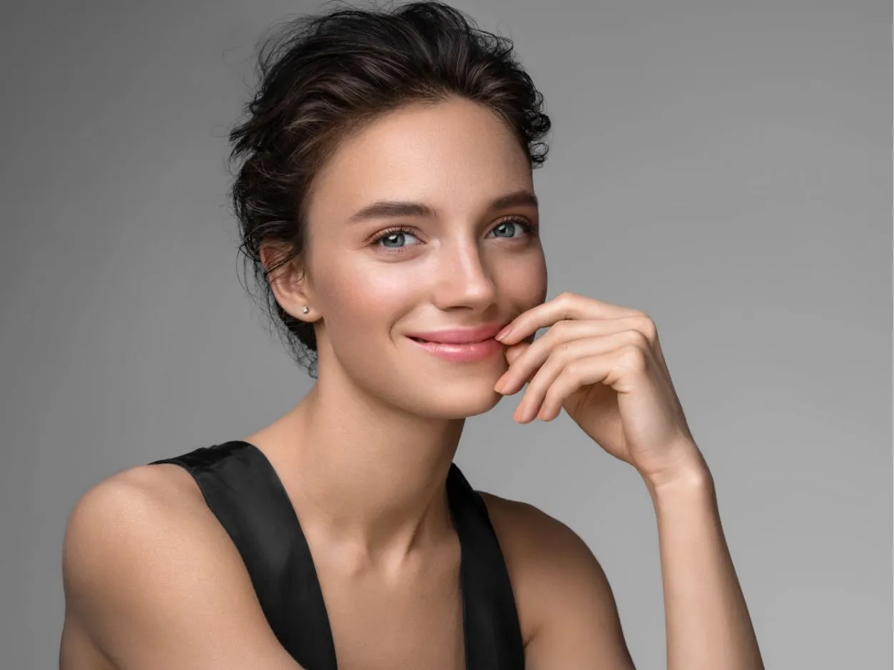 a closeup of a woman with her hand resting against her left face