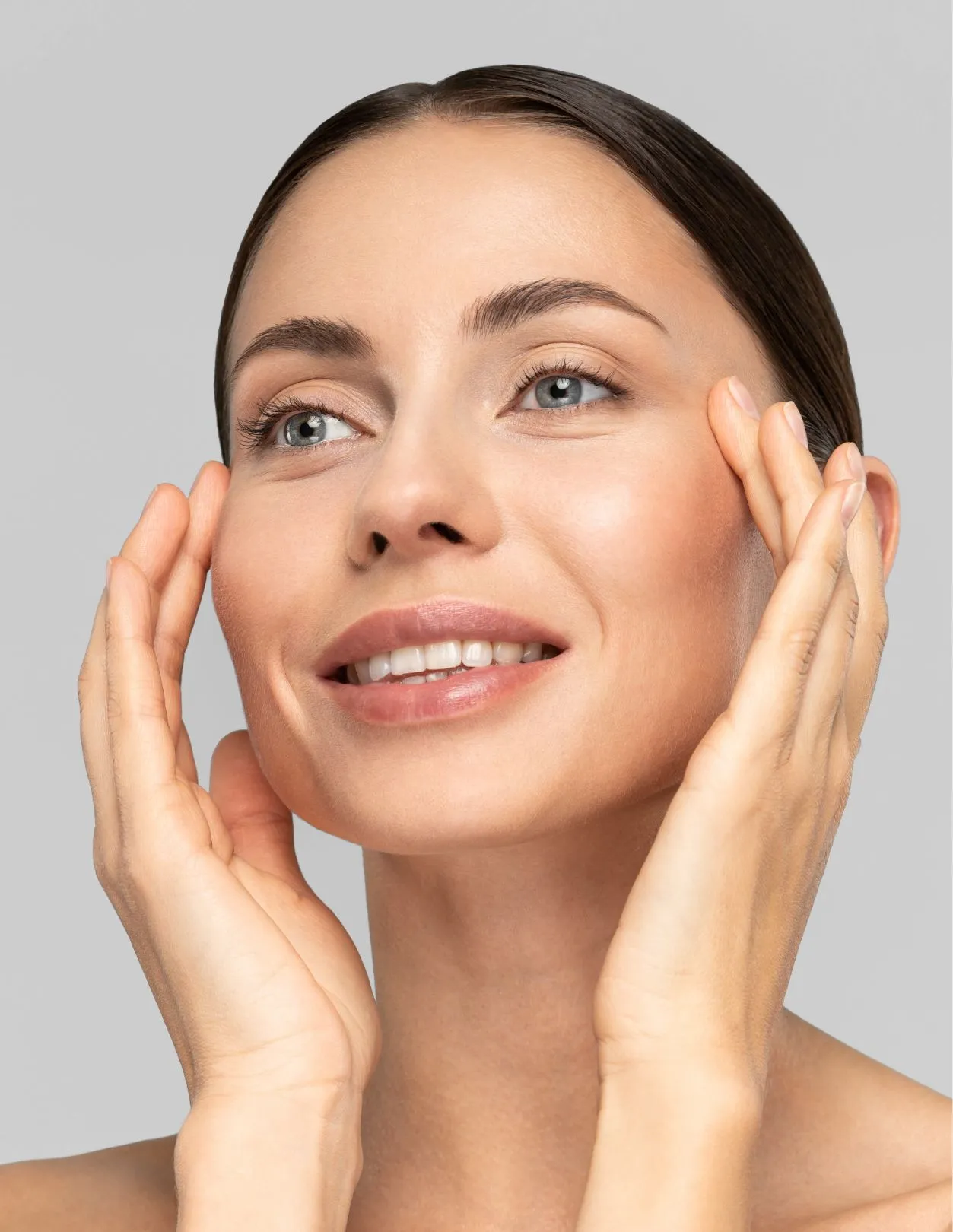 a woman gently touching her face pulling back her skin around her eyes